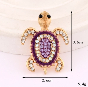 Detailed macro view showing a crystal sea turtle brooch with purple rhinestones