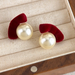 Detailed shot of vintage burgundy flocked earrings with cream pearls in a wooden box