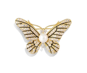 Macro detail of butterfly brooch with sparkling crystals, white pearl, and golden frame