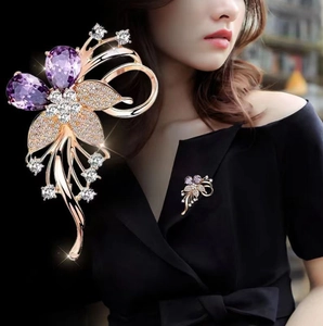 Détail macro d'une luxueuse broche fleur aux cristaux violets et finition or rose