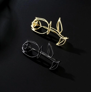 Detailed view of minimalist cutout rose brooches in elegant gold and black metal finish