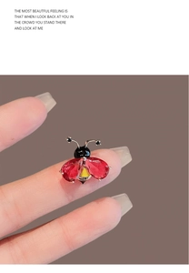 Vue macro d'une broche abeille avec ailes en cristal rouge et corps rayé jaune