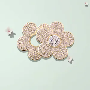 Minimalist gold flower brooch with sparkling white cubic zirconia and a center stone