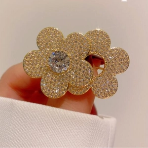Elegant gold flower brooch with white zircons and a large centerpiece stone