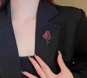 Primer plano de un broche de rosa púrpura vintage con circonitas en solapa de traje