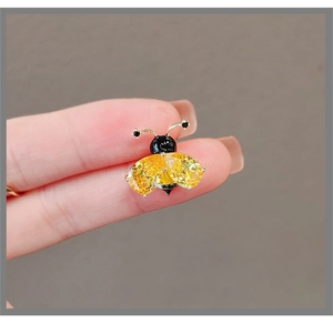 Détail d'une petite broche abeille avec cristaux jaunes en poire et émail noir élégant