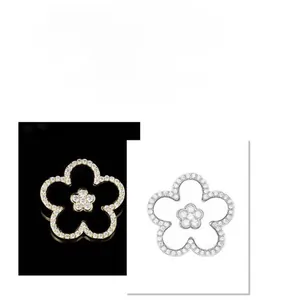 Macro detail of elegant black five-petal flower brooch with sparkling diamond-set borders