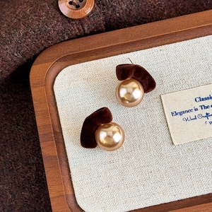 Detail of vintage brown flocked fan-shaped earrings with champagne pearls and velvet texture