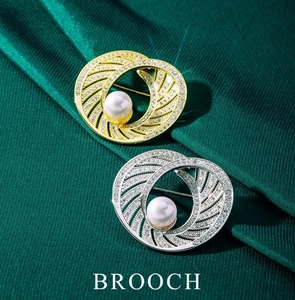 Detailed view of intertwined gold and silver brooches with pearls and crystals