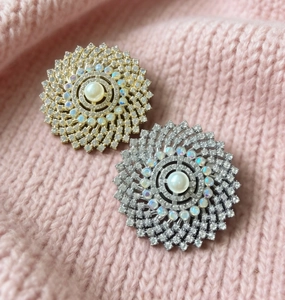 Detailed view of luxury sunflower brooches with pearls and rhinestones on pink knit fabric