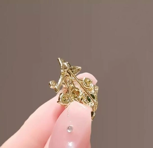 Detail view of the back pin closure on a gold-plated grape brooch with colorful rhinestones