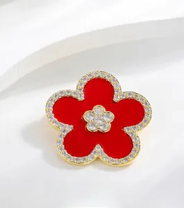 Macro shot of the black enamel flower brooch with sparkling diamond-set gold edges