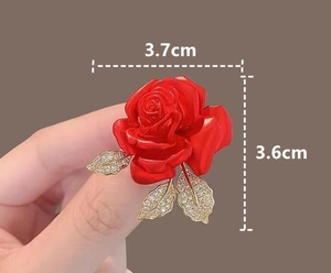 Détail macro de la broche rose rouge émaillée avec feuille d'or, taille 3,7cm x 3,6cm