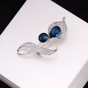 Broche élégante en forme de feuille d'argent avec zircons blancs et cristaux bleus