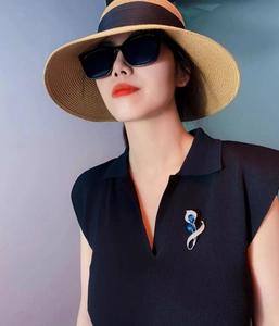 Gros plan détaillé d'une broche calla argentée avec pierres bleues sur robe noire