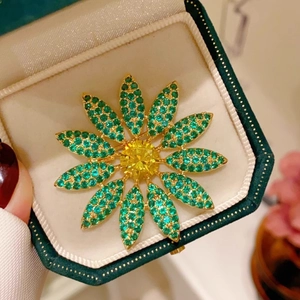 Luxury maple flower brooch with green crystals and yellow center stone in a gift box