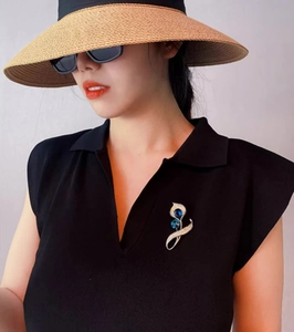 Broche calla élégante avec cristaux bleus épinglée sur le revers d'une veste noire