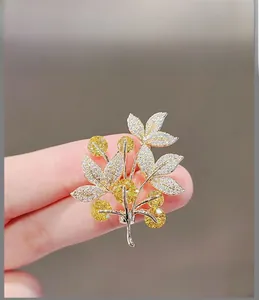 Detailed view of lucky tree brooch with yellow gemstones and sparkling leaf inlay
