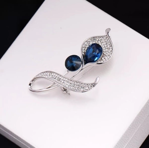 Broche élégante en lys calla avec cristaux bleu profond et strass brillants en boîte
