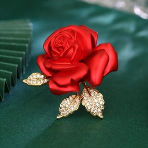 Macro de broche rose en satin rouge avec feuilles dorées et diamants incrustés