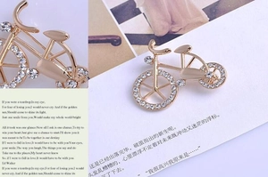 Detail macro view showing vintage gold bicycle brooch with white crystal rhinestones inlay