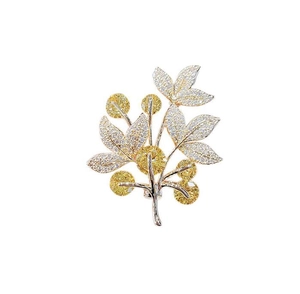Detailed close-up of a silver lucky tree brooch with yellow and white zircon inlay