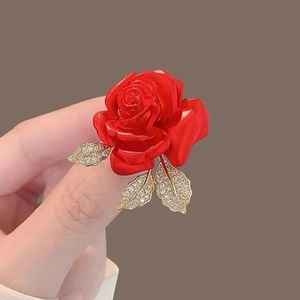 Bague élégante rose rouge avec feuilles dorées et cristaux blancs sur fond marron