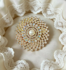 Macro detail of luxury flower brooch with center pearl and sparkling rhinestones
