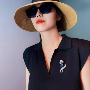 Broche calla élégante avec cristaux bleus et zircons sur un vêtement noir col V