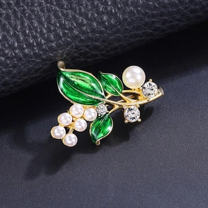Elegante spilla a pianta con foglie in smalto verde, perle e cristalli su base dorata