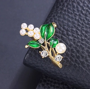 Elegante spilla a forma di pianta con foglie in smalto verde e perle su pelle nera