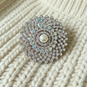 Elegant vintage starburst pearl brooch with shimmering rhinestones on a knit sweater