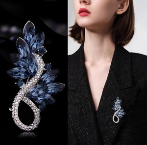 Détail macro d'une broche plume en cristal bleu de luxe avec micro-pavage de cristaux argentés