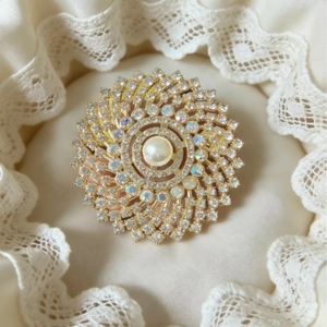 Elegant gold sunflower brooch with a large central pearl and sparkling crystal petals