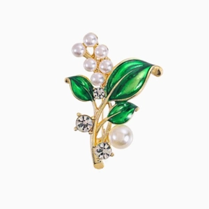 Elegante bladbroche met groen emaille, witte parels en sprankelende kristallen op wit