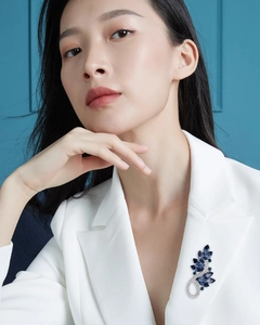 Élégante broche feuille en cristal bleu sur un blazer blanc avec finition argentée luxe