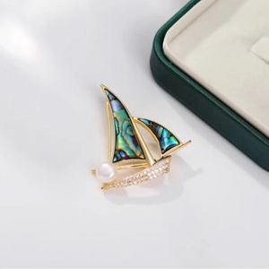 Broche voilier dorée avec nacre d'abalone, perle blanche et zircons brillants