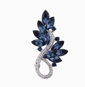 Détail de la broche de luxe avec cristaux bleu marine et strass argentés sur courbe en S