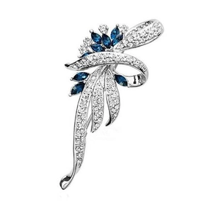 Detail of silver floral brooch with blue marquise gems and white pavé crystals