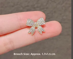 Detail showing bow knot brooch with zircons, size approximately 1.7cm by 1.5cm