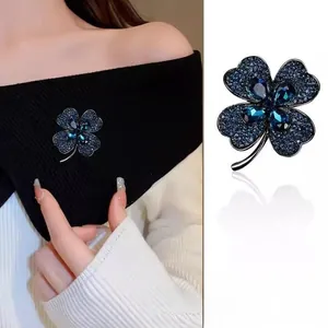 Détail macro de la broche trèfle en cristal bleu avec strass bleu foncé en gros plan