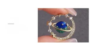 Detail view of fantasy planet brooch with blue enamel and sparkling cubic zirconia crystals