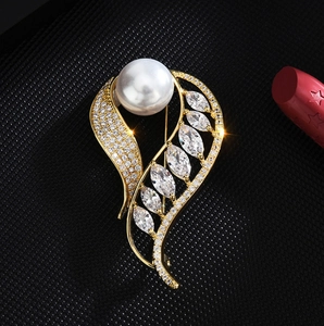 Élégante broche feuille dorée avec perle blanche et zircon marquise sur fond noir