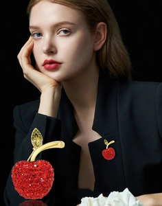 Detailed view of luxury cherry brooch featuring sparkling red crystals on gold branch