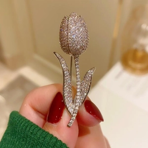 Close-up of elegant tulip brooch with shimmering white zircons on silver metal base