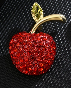 Detailed macro view of high-end red apple brooch with crystal pavé and gold plating