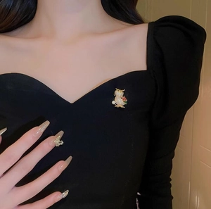 Exquisite owl brooch with white and green crystals and pearl on black clothing