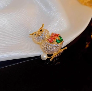 Elegant gold owl brooch with white zircons, colorful gemstones and pearl on branch