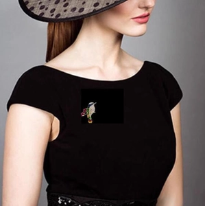 Broche colibri étincelante avec strass colorés sur une robe noire avec chapeau
