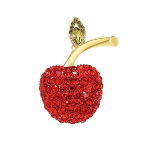 Macro detail of luxury cherry brooch with red rhinestones and gold leaf texture